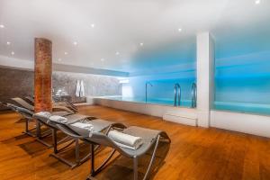 a room with a row of chairs and a swimming pool at Hôtel Montaigne & Spa - Cannes Centre in Cannes +42 photos