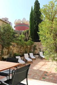 a patio area with chairs, tables and umbrellas at The Museum Apartments in Figueres