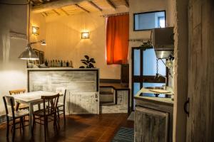 una cucina e una sala da pranzo con tavolo e sedie di La Tana Del Ghettaccio a Viterbo