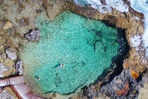 una persona nadando en un cuerpo de agua en Mia Reef Isla Mujeres Cancun All Inclusive Resort en Isla Mujeres