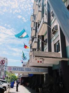 a hotel with flags flying outside of a building at Hotel Vera Cruz in Ijuí