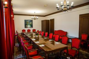 uma sala de conferências com uma mesa longa e cadeiras vermelhas em Hotel Grand em Valjevo