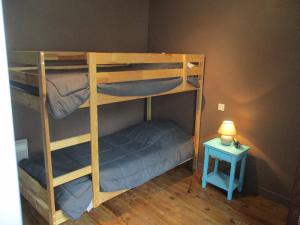 2 Etagenbetten in einem Zimmer mit einem Beistelltisch in der Unterkunft L'estaou in Lavoûte-Chilhac