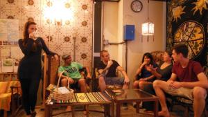 
a large group of people sitting around a living room at Backpackers Hotel Toyo in Osaka
