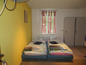 two beds in a small room with a window at Zimmervermietung zum See in Wolteritz