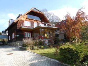 a wooden house with a porch and a balcony at Willa auf der Steinplatte in Teufenbach