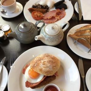 una mesa con platos de desayuno y una tetera en The Hideaway At Windermere (Adults only), en Windermere