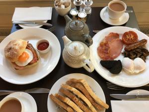 una mesa cubierta con platos de desayuno y café en The Hideaway At Windermere (Adults only), en Windermere