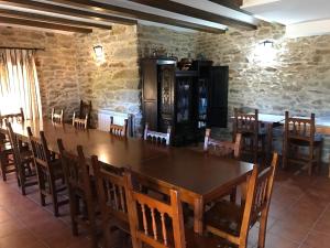 une salle à manger avec une grande table et des chaises en bois dans l'établissement Cabañas Maleixas, à El Puente