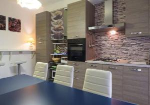 cocina con mesa azul y sillas blancas en Casa Claudia Appartamento non condiviso, en Montecassiano