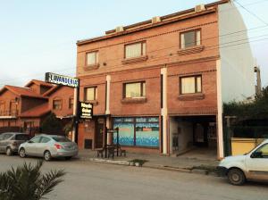 un edificio de ladrillo con coches estacionados frente a él en Rincon Gales en Puerto Madryn