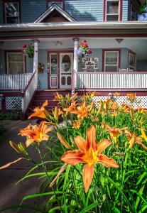 a house with a bunch of flowers in front of it at Holden House 1902 Bed & Breakfast Inn in Colorado Springs