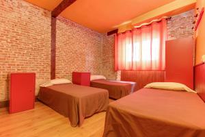Una habitación con dos camas y una pared de ladrillo. en Sweet Home Salamanca, en Salamanca