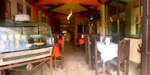 un restaurante con mesas y sillas y una barra con comida en Hotel Tres Marías, en San Cristóbal de Las Casas