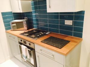 a kitchen with a stove and a toaster oven at Townhouse @ Balliol Street Stoke in Stoke on Trent