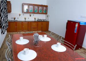 Una cocina con una mesa y un refrigerador rojo. en Holiday Villa, en Thekkady