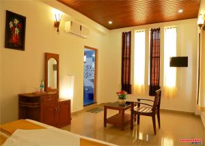 a living room with a table and a mirror at Holiday Villa in Thekkady