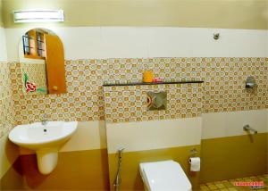 un baño con lavabo e inodoro en Holiday Villa, en Thekkady 4 fotos más