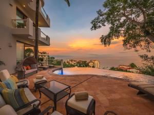 a patio with furniture and a view of the sunset at Villa Divina Luxury in Puerto Vallarta