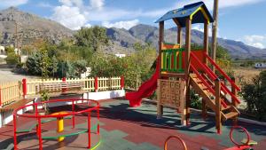 um parque infantil com um escorrega e uma estrutura de brincar em Kritamos Beach Apartments em Frangokastello