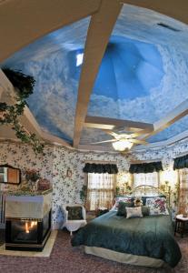 a bedroom with a large bed with a blue ceiling at Holden House 1902 Bed & Breakfast Inn in Colorado Springs