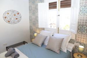 a bedroom with a bed with white pillows and a window at APARTAMENTO GRANADA CENTRO in Granada
