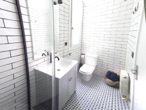 Baño blanco con lavabo y aseo en Luxury Cuchillería Vitoria, en Vitoria-Gasteiz
