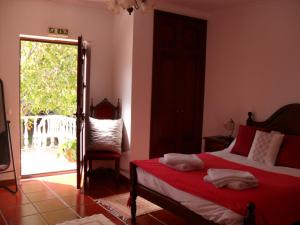 a bedroom with a bed and a sliding glass door at Casa Vale Florido in Alvorge