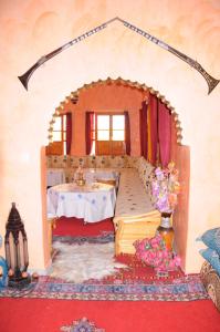una sala de estar con una mesa y una habitación con una mesa en Kasbah Elmehdaoui en Skoura