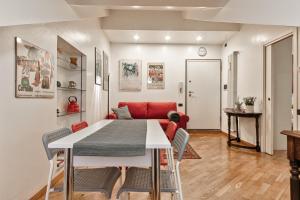 salon ze stołem i czerwoną kanapą w obiekcie Acadamis - Apartment Cleopatra w Turynie
