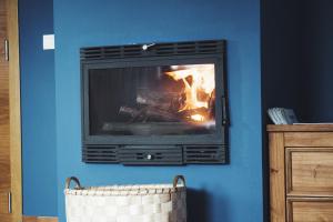 una chimenea en una habitación con una pared azul en Albergue Camino Norte, en Castropol