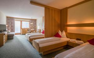 una camera d'albergo con due letti e una televisione di Post Appartements a Strass im Zillertal