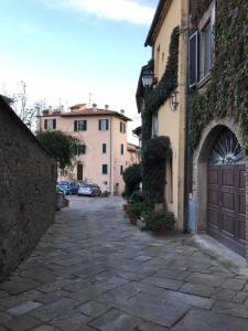 an alley in a town with buildings and cars at Tre Girasoli in Monte San Savino