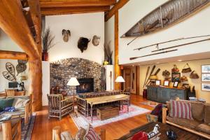 - un salon avec une cheminée en pierre et une table dans l'établissement Moraine Lake Lodge, à Lake Louise