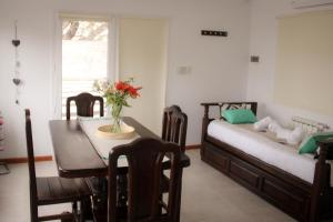 a room with a table and a bed and a table and chairs at Del Sol Apart in Sarmiento