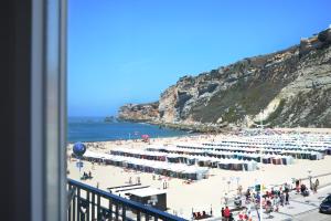 a view of a beach with umbrellas and the ocean at Hotel Mar Bravo in Nazaré