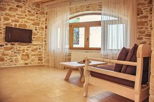 a room with a couch and a table and a tv at Villa Kapela in Sívas