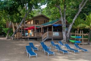 um grupo de cadeiras e uma casa com parque infantil em Blue Island Divers Casita Azul em Sandy Bay