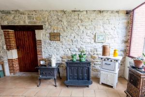 - une cuisine avec une cuisinière et un mur en briques dans l'établissement Chambres d'Hôtes Domaine du Bourg, à Gannay-sur-Loire