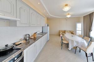 a kitchen with a table and a dining room at Apartment Lux 177 A in Astana