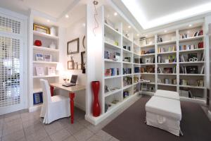 a library with a desk and book shelves at Hotel Darsena in Riccione