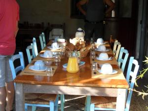 a long wooden table with plates and dishes on it at Chambres d'Hôtes Domaine du Bourg in Gannay-sur-Loire