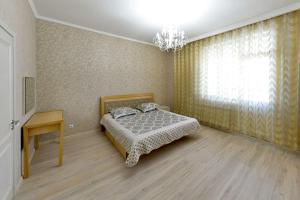 een slaapkamer met een bed, een tafel en een raam bij Apartment Lux 177 A, ЭКСПО, Mega Silky Way in Astana
