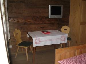 una stanza con tavolo, due sedie e televisore di Malernhof a Kitzbühel