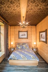 ペレスラヴリ・ザレスキーにあるZalesskaya Provinziyaの木製の部屋にベッド1台が備わるベッドルーム1室があります。