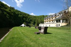 a large grassy field next to a large building at Cocoon Hotel Belair in Bourscheid