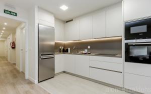 a kitchen with white cabinets and a stainless steel refrigerator at Apartamento Buen Camino in Pamplona