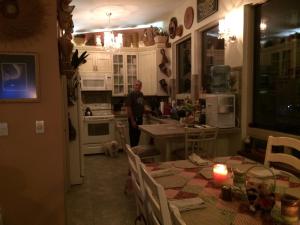 Black Bear Inn في كيتشيكان: رجل واقف في مطبخ مع طاوله