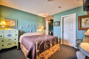 a bedroom with a bed with a purple comforter at Sandy Cove Inn in Seaside