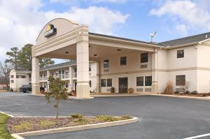 un gran edificio blanco con aparcamiento en Days Inn by Wyndham Fordyce, en Fordyce